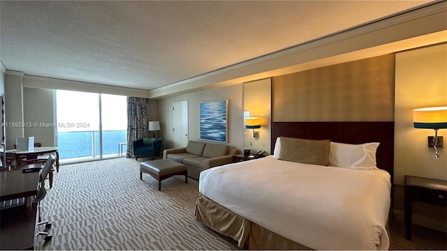 carpeted bedroom with access to outside, a water view, a textured ceiling, and ornamental molding