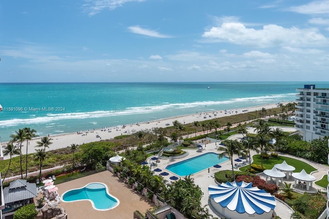 birds eye view of property with a water view and a beach view