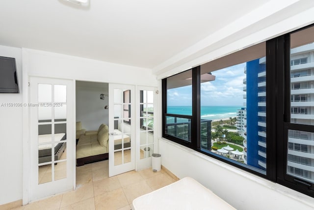 tiled bedroom featuring french doors and a water view