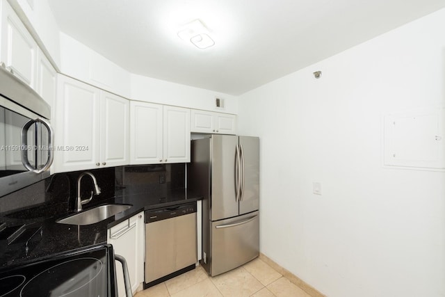 kitchen with light tile patterned floors, decorative backsplash, appliances with stainless steel finishes, and white cabinetry