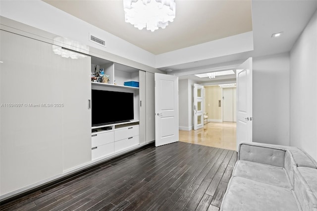 unfurnished living room with dark hardwood / wood-style floors and a chandelier