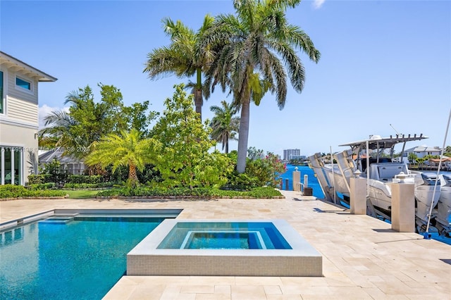 view of pool with an in ground hot tub, a water view, and a patio