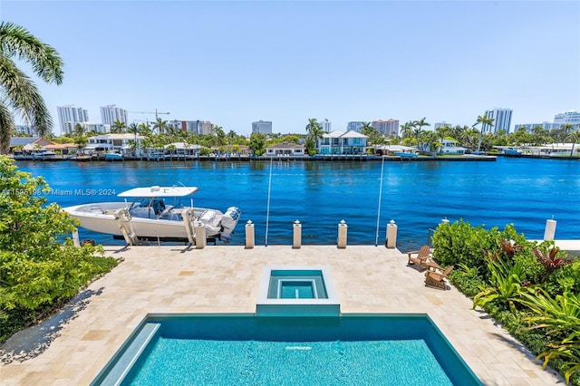 exterior space featuring an in ground hot tub, a water view, and a patio