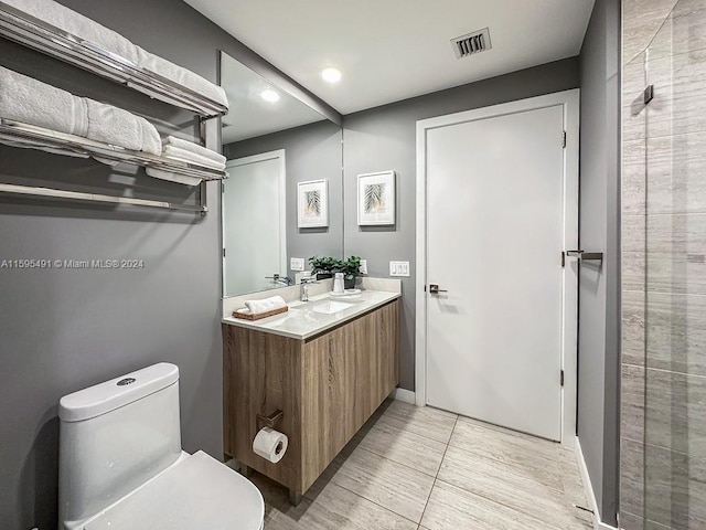 bathroom with tile patterned flooring, vanity, and toilet