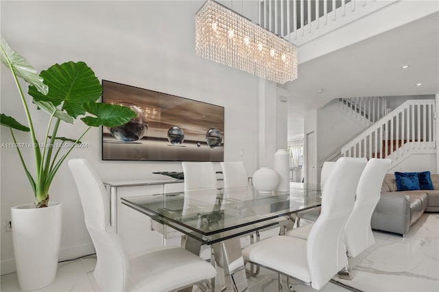 dining area featuring a notable chandelier, a high ceiling, and light tile floors