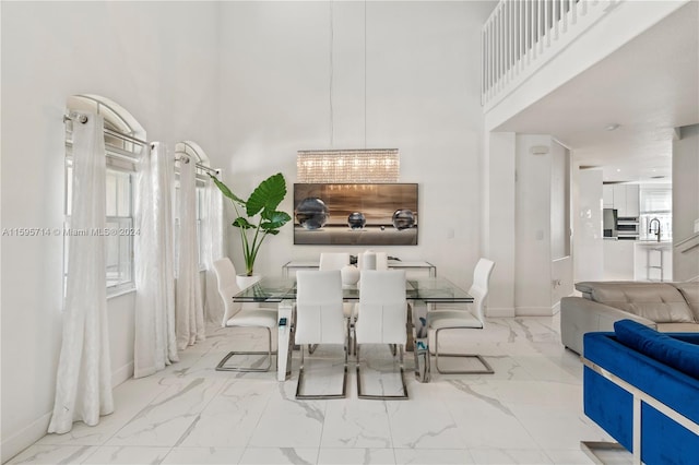 tiled dining space featuring a towering ceiling and sink