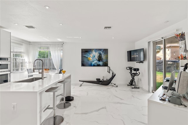 kitchen featuring recessed lighting, light countertops, visible vents, a sink, and baseboards