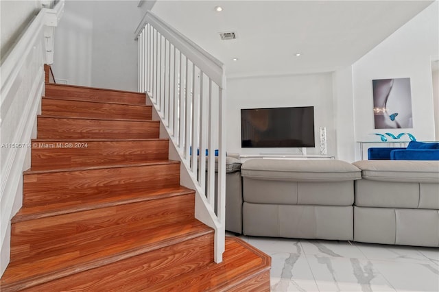 stairway featuring visible vents, recessed lighting, and marble finish floor