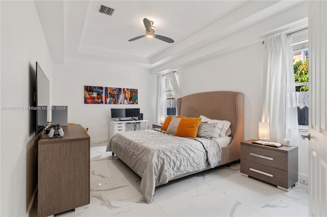 bedroom with a ceiling fan, marble finish floor, a tray ceiling, baseboards, and visible vents