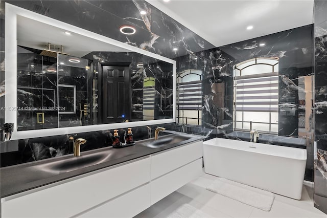 bathroom featuring a tub, tile flooring, dual sinks, and large vanity