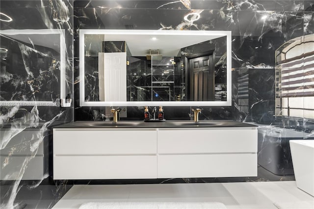 full bathroom with marble finish floor, a sink, a shower, and double vanity