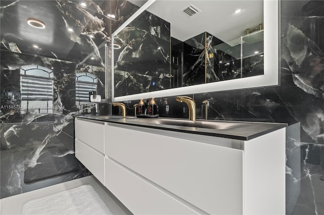 full bath featuring visible vents, marble finish floor, a sink, and double vanity
