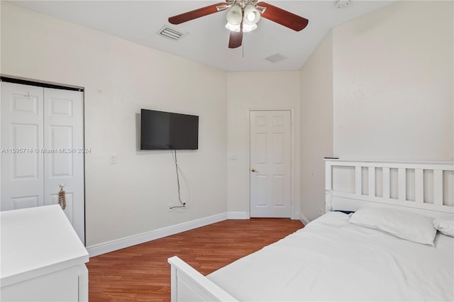 bedroom featuring wood finished floors, visible vents, a ceiling fan, a closet, and baseboards
