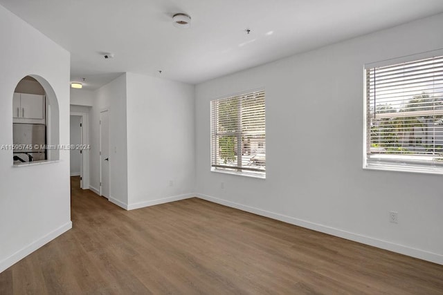 spare room with a wealth of natural light and hardwood / wood-style flooring