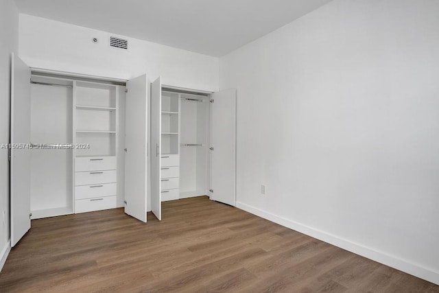 unfurnished bedroom with a closet and wood-type flooring