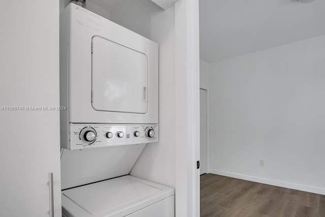 laundry room with stacked washer and clothes dryer and dark hardwood / wood-style flooring