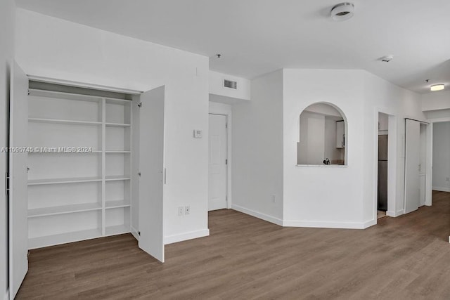 interior space with stainless steel refrigerator and hardwood / wood-style flooring