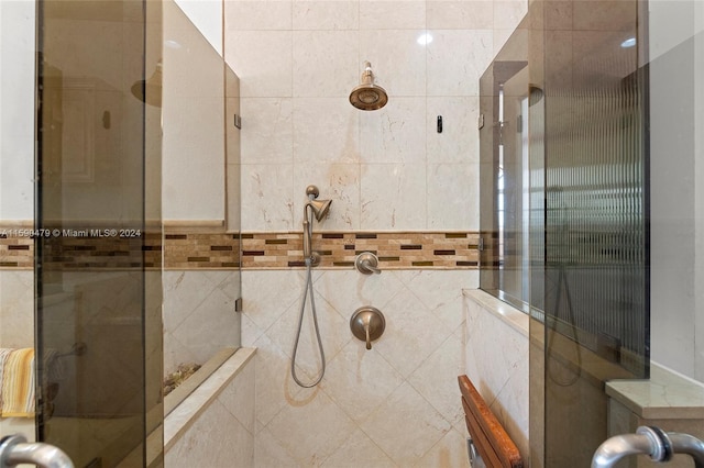 bathroom featuring an enclosed shower and tile walls