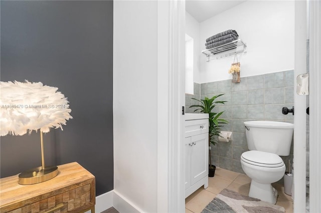 bathroom featuring tile patterned flooring, toilet, and tile walls