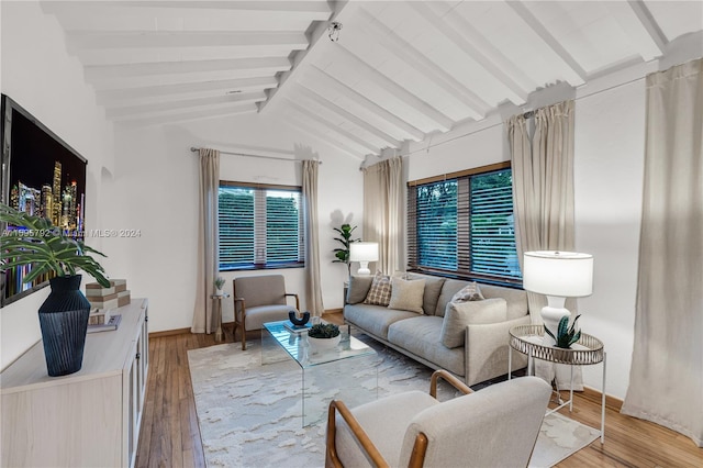 living room with vaulted ceiling with beams and light wood-type flooring