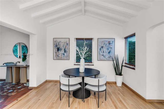 dining area with hardwood / wood-style flooring and lofted ceiling with beams