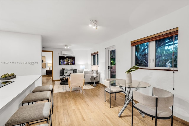 dining room featuring light wood-type flooring and a wall mounted AC