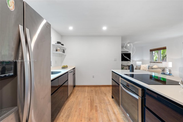 kitchen with dark brown cabinets, stainless steel appliances, and light hardwood / wood-style floors