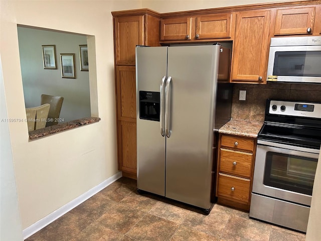 kitchen featuring tasteful backsplash, stone countertops, and appliances with stainless steel finishes