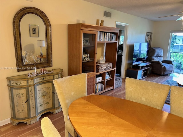 dining room with a textured ceiling, hardwood / wood-style flooring, and ceiling fan