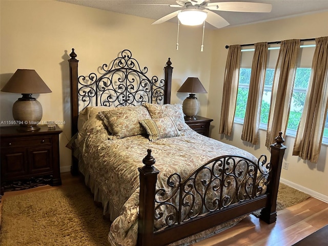 bedroom with dark hardwood / wood-style flooring and ceiling fan