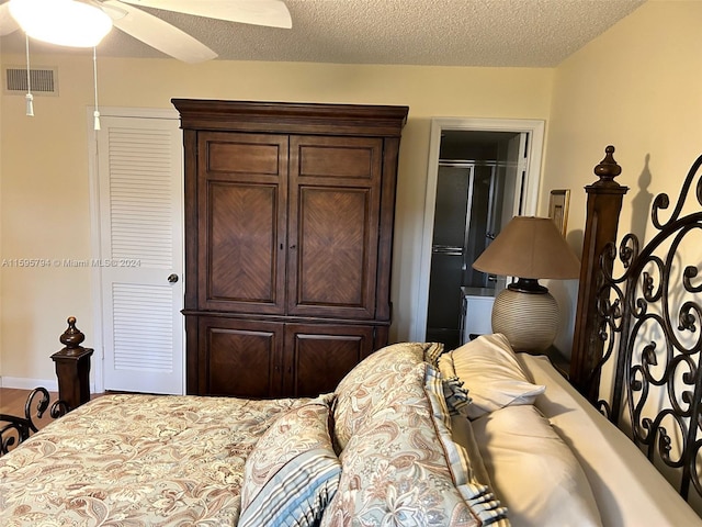 bedroom with a walk in closet, ceiling fan, a closet, and a textured ceiling