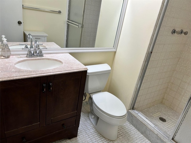 bathroom featuring toilet, vanity, tile patterned floors, and an enclosed shower