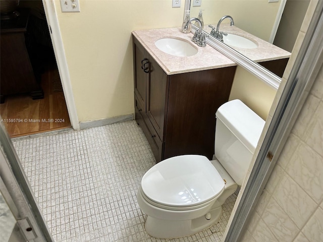 bathroom featuring tile patterned flooring, vanity, and toilet