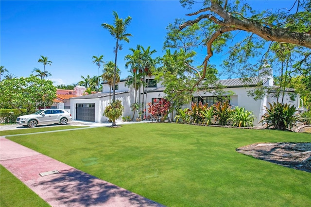 view of front of house featuring a front lawn and a garage