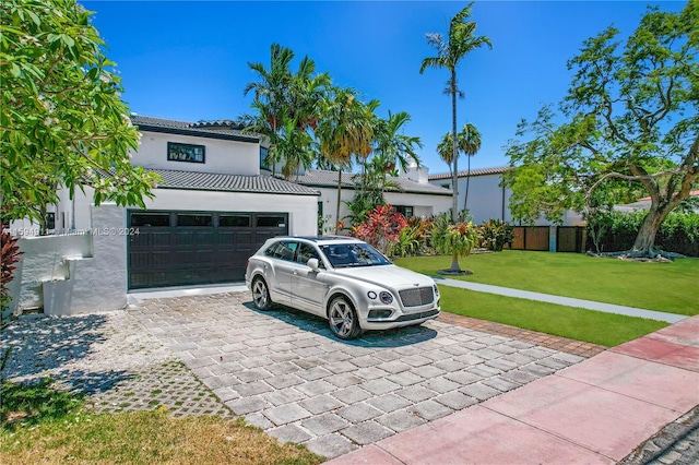 view of front of property with a front yard and a garage