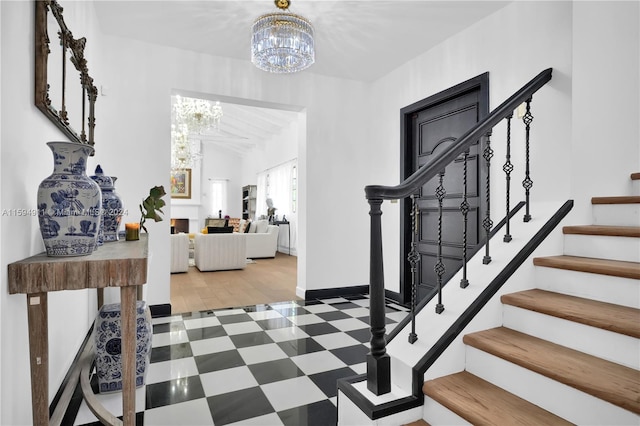 stairway with wood-type flooring and a notable chandelier