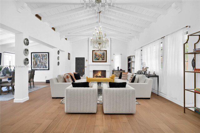 living room featuring beam ceiling, light wood-type flooring, a fireplace, and high vaulted ceiling