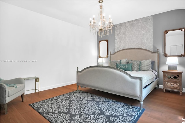 bedroom with hardwood / wood-style flooring, an inviting chandelier, and lofted ceiling