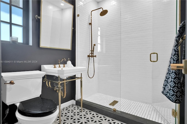 bathroom featuring sink, an enclosed shower, and toilet