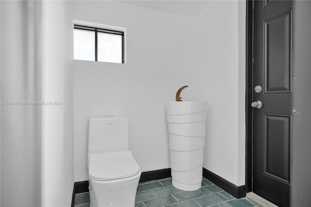 bathroom with toilet and tile patterned floors