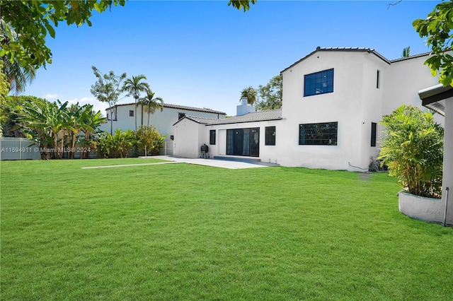 rear view of property featuring a yard and a patio