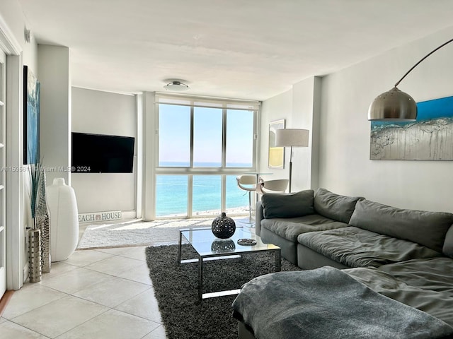 tiled living room with a wall of windows and a water view