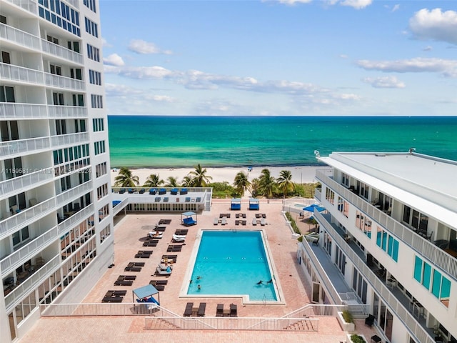 community pool featuring a view of the beach and a water view