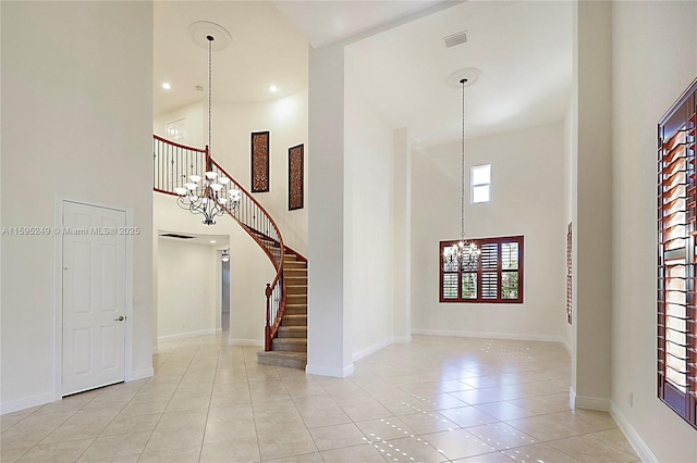 tiled foyer with a notable chandelier and a towering ceiling