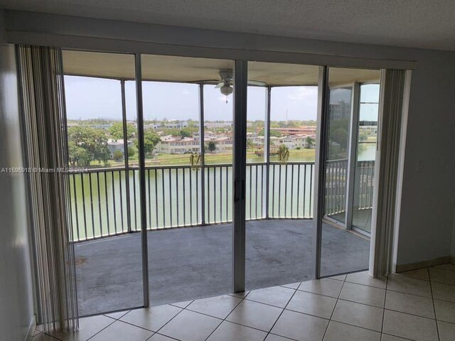 unfurnished sunroom with ceiling fan