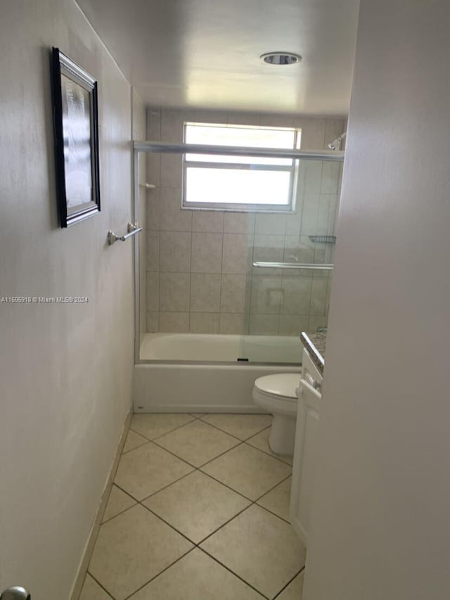 full bathroom featuring vanity, combined bath / shower with glass door, tile patterned floors, and toilet