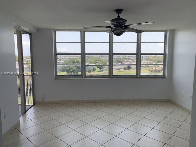 spare room featuring plenty of natural light, light tile patterned floors, and ceiling fan