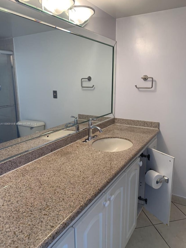 bathroom with vanity, walk in shower, tile patterned floors, and toilet