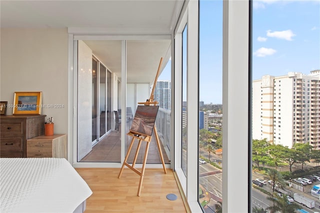 bedroom with light hardwood / wood-style floors and expansive windows