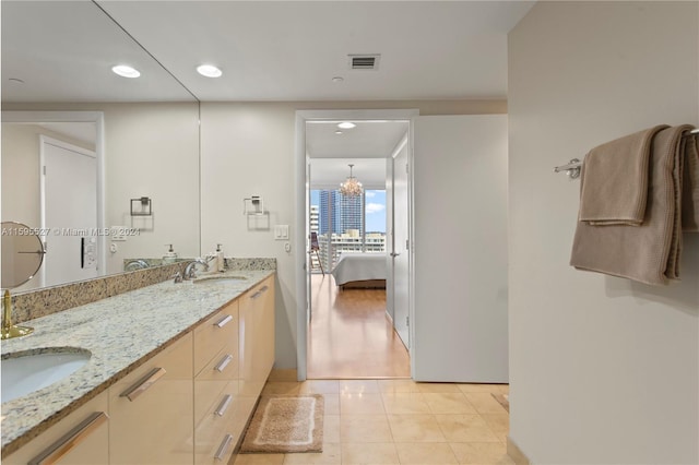 bathroom featuring tile patterned floors, vanity, and a notable chandelier